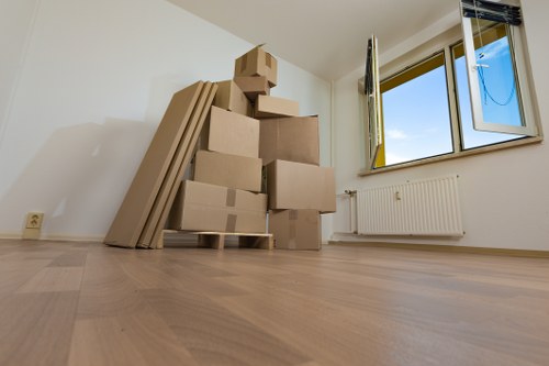 Movers protecting a sofa and wooden table for transport