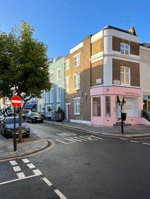 Image showing a row of Victorian-style terraced houses in Notting Hill, London, with distinctive bay windows and decorative facades painted in various pastel and vibrant colours such as blue, pink, cr